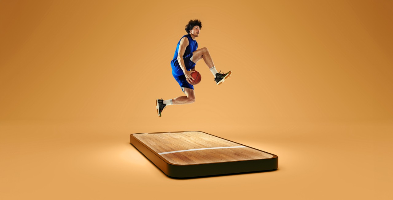 Person with basketball jumping over a tablet