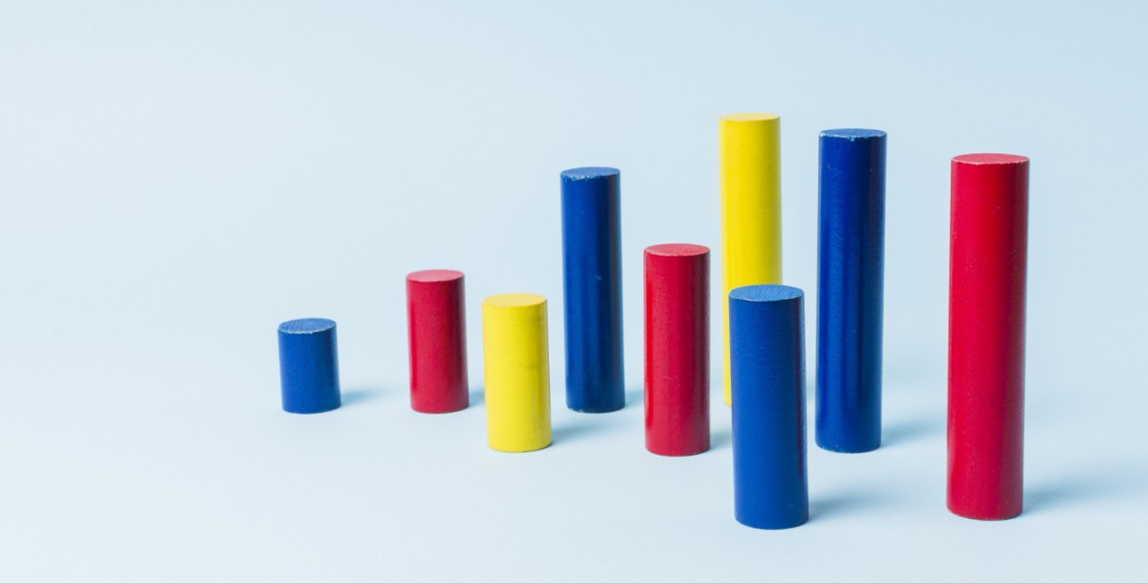 Different sized and colored cylinders on a neutral background